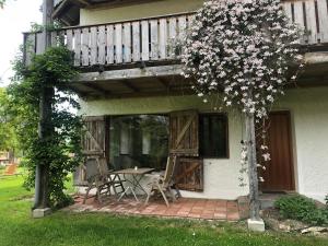 eine Veranda eines Hauses mit einem Tisch und einem Balkon in der Unterkunft Biohof Pürten in Waldkraiburg