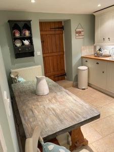 eine Küche mit einem Holztisch im Zimmer in der Unterkunft ‘The Nest’ A beautiful cottage in Devon in Axminster