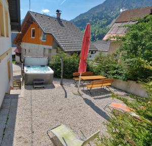a patio with a hot tub and a bench and an umbrella at Jacobs 4 Bedroom Private House in Kranjska Gora