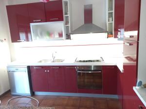 een keuken met rode kasten en een wastafel bij Appartamento Ambra in Librizzi