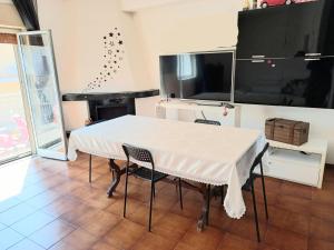 een witte tafel en stoelen in een kamer met een piano bij Appartamento Ambra in Librizzi