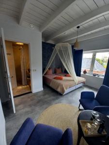 a bedroom with a bed with a mosquito net at BnB-Heirhuys in Visvliet