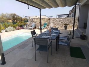 a patio with a table and chairs and a pool at Le Domaine De Marie in Palasca