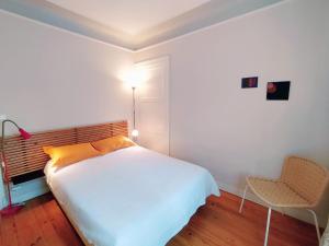 um quarto com uma cama, um candeeiro e uma cadeira em Villa Dziunia Jardin Terrasse ok em Tarnos