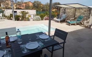 a table with plates on it next to a swimming pool at Le Domaine De Marie in Palasca