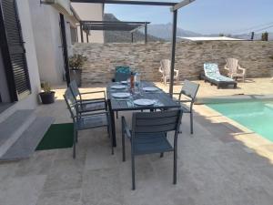 a patio with a table and chairs next to a pool at Le Domaine De Marie in Palasca
