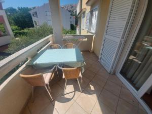 einen Balkon mit einem Tisch und Stühlen in der Unterkunft Apartment Ive in Baška