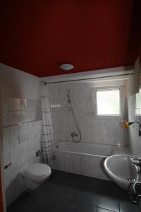 ein Badezimmer mit einer Badewanne, einem WC und einem Waschbecken in der Unterkunft Ferienwohnung Haus Ella in Neunkirchen
