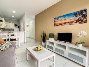 a living room with a couch and a tv at Sunset Lover Playa Jardin in Puerto de la Cruz