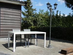 a white table and chairs next to a street light at Midden in de natuur, een ruim chalet aan de rand van het bos, nr 30 in Marum +48 photos
