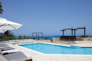 a swimming pool with chairs and an umbrella at Alpha Luxury & Spa Villa in Rethymno Town