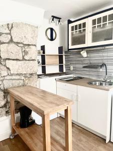 a kitchen with a wooden table and a stone wall at Apartments Rome in Baška