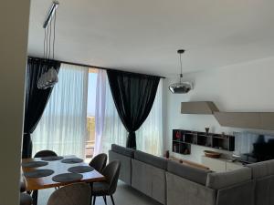 a living room with a couch and a table at Green Coast 136 in Dhërmi