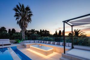 een patio met een bank en een zwembad bij Alpha Luxury & Spa Villa in Rethimnon