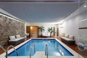 een zwembad in een huis met een woonkamer bij Alpha Luxury & Spa Villa in Rethimnon