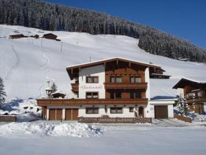 ein großes Gebäude im Schnee vor einem Berg in der Unterkunft Glockenstuhl, Haus in Tux