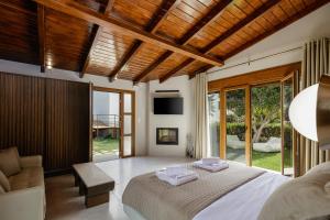 a bedroom with a bed and a couch and windows at Alpha Estate & Spa in Rethymno