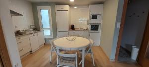 a kitchen with a table and chairs in a room at Piso Covian in Ribadesella