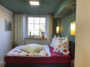 ein Schlafzimmer mit einem Bett mit Kissen und einem Fenster in der Unterkunft Ferienwohnung Schubertstraße in Malchow