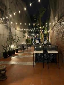 un patio con mesa, sillas y luces en Local Backpacker Hostel, en Tainan