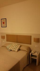 a bedroom with a bed with a pillow and a table at Hotel Lucerna in Castiglione della Pescaia
