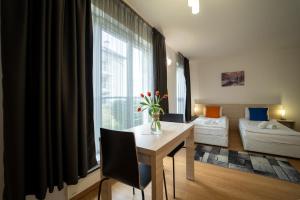 uma sala de estar com uma mesa com um vaso de flores em Saint George Palace Aparthotel em Bansko