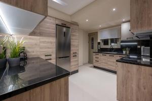 uma cozinha com um frigorífico de aço inoxidável e armários de madeira em ''Aeolos'' Luxury Villa em Preveza