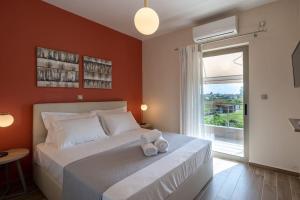um quarto com uma grande cama branca e uma janela em ''Aeolos'' Luxury Villa em Preveza
