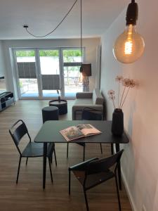 a living room with a table and chairs at Apartmenthaus Stade Schwingewiesen Apartment 2 in Stade