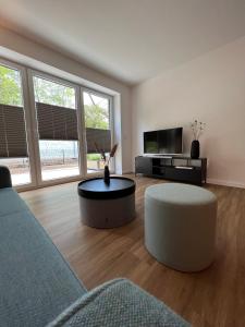 a living room with a couch and a table at Apartmenthaus Stade Schwingewiesen Apartment 3 in Stade +7 photos