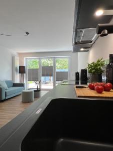 une cuisine avec un comptoir avec des tomates sur une planche de découpe dans l'établissement Apartmenthaus Stade Schwingewiesen Apartment 3, à Stade