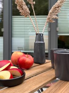 a wooden cutting board with apples and a vase at Apartmenthaus Stade Schwingewiesen Apartment 4 in Stade