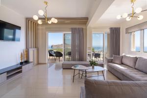 a living room with a couch and a tv at Villa Aretousa 2 in Agia Marina Nea Kydonias