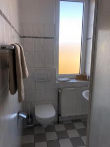 a bathroom with a toilet and a sink and a window at Pension Highway Bünde Hansastraße in Bünde