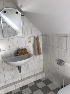 a white bathroom with a sink and a mirror at Pension Highway Bünde Hansastraße in Bünde