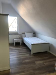 ein kleines Schlafzimmer mit einem Bett und einem Fenster in der Unterkunft Pension Highway Bünde Hansastraße in Bünde