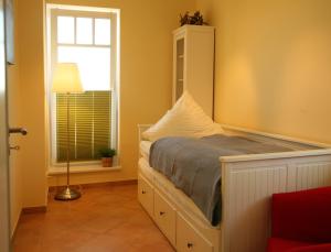 Schlafzimmer mit einem Bett und einem Fenster in der Unterkunft Apartment Strandkate Wohnung Strandhafer in Börgerende-Rethwisch