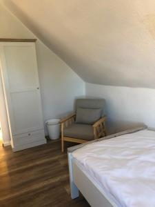 a bedroom with a bed and a chair in a attic at Pension Highway Bünde Hansastraße in Bünde