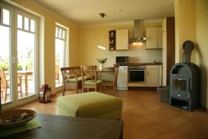 a kitchen and living room with a stove in it at Apartment Strandkate Wohnung Strandhafer in Börgerende-Rethwisch