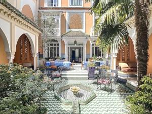 um pátio de um edifício com uma mesa e cadeiras em Magnifique Riad avec patio extérieur em Vichy