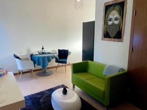 a living room with a green couch and a table at Apartament przy lesie in Chojno