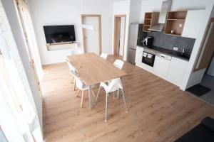 eine Küche und ein Esszimmer mit einem Holztisch und Stühlen in der Unterkunft Family XL - Bungalows in Lutzmannsburg