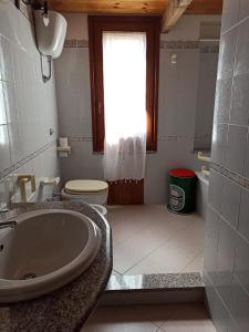 a bathroom with a sink and a toilet and a tub at Il giglio vista mare num iun Q6084 in Funtana Meiga
