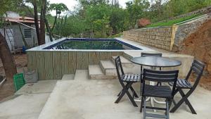 a patio with a table and chairs and a swimming pool at Quitinetes Beira Rio in Canindé de São Francisco