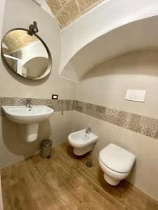 Un baño con lavabo, inodoro y espejo. en B&B Gallina 18, en Bari