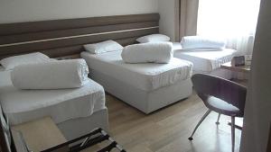 um quarto com 3 camas, uma cadeira e uma secretária em BAL Mini Hotel em Tirebolu