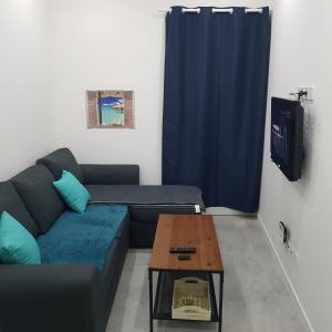 sala de estar con sofá y mesa en Appart 40m2 indépendant, confortable avec terasse, en Lunel