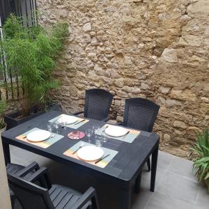 a black table with chairs and plates on it at Appart 40m2 indépendant, confortable avec terasse in Lunel