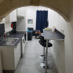 a kitchen with a counter and stools in a room at Appart 40m2 indépendant, confortable avec terasse in Lunel