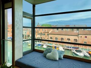 um quarto com uma grande janela com barcos na água em Residence Laguna Giudecca em Veneza